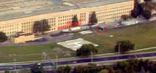 Fachada del Pentágono antes del impacto. Fotografía tomada el 25 de agosto de 2001 (<a class="url" href="http://investigate911.bravehost.com/">fuente</a>). La zona roja indica el agujero de entrada del avión. El círculo rojo indica la posición del generador.